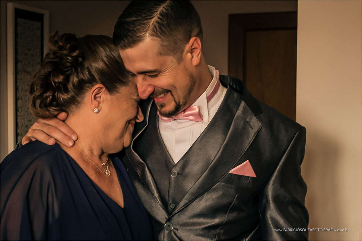 mãe do noivo ainda muito emocionada fazendo um carinho no filho