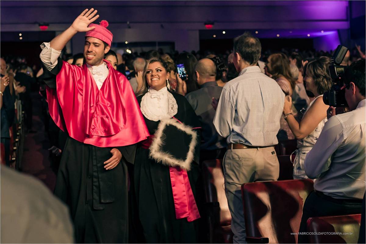 entrada da oradora da turma junto com o professor paraninfo para o momento de colação de grau em ciências contábeis da PUCRS