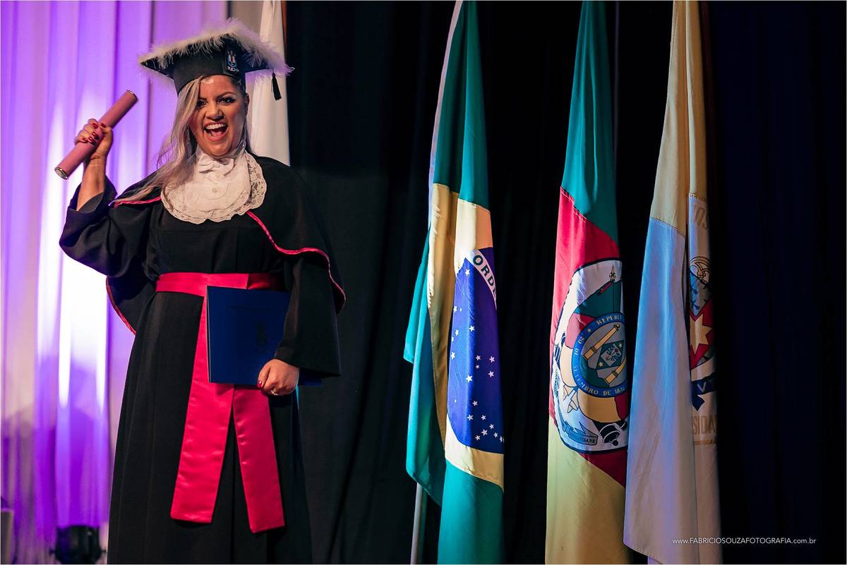 rosangela ao lado das bandeiras do brasil, bandeira do rio grande do sul e bandeira da PUCRS