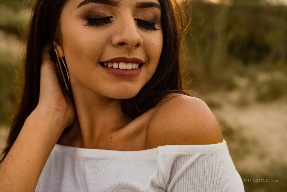 izabella com os cabelos voando ao vento contornado pelo sol de um belo fim de tarde na bela praia de torres/rs no ensaio da izabella, por fabricio souza, fotografo no rs, porto alegre e região