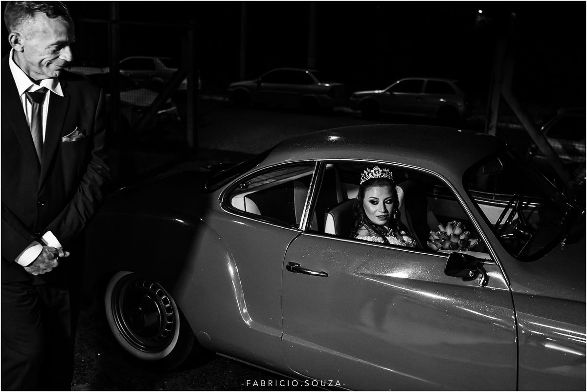 a noiva no karmann ghia vermalho aguardando o momento de entrar na igreja sendo observada de perto por seu pai, momento muito emocionante dando aquela espiada para o noivo que aguarda ansioso no altar, por fabricio souza fotografo