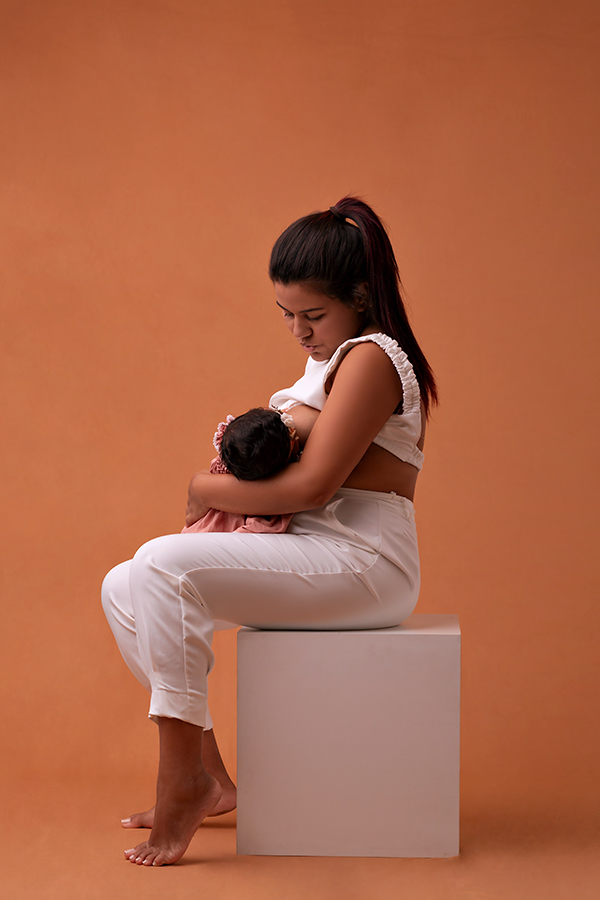 Mãe amamentando filha em ensaio de acompanhamento do bebê em Natal RN no Amoradia Foto.