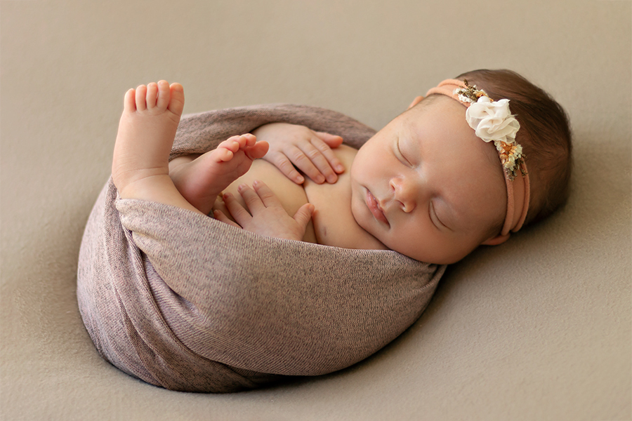 Ensaio Newborn. Foto de bebê de barriga pra cima em poof. Fotógrafo Newborn em Natal. Anny Barreto.