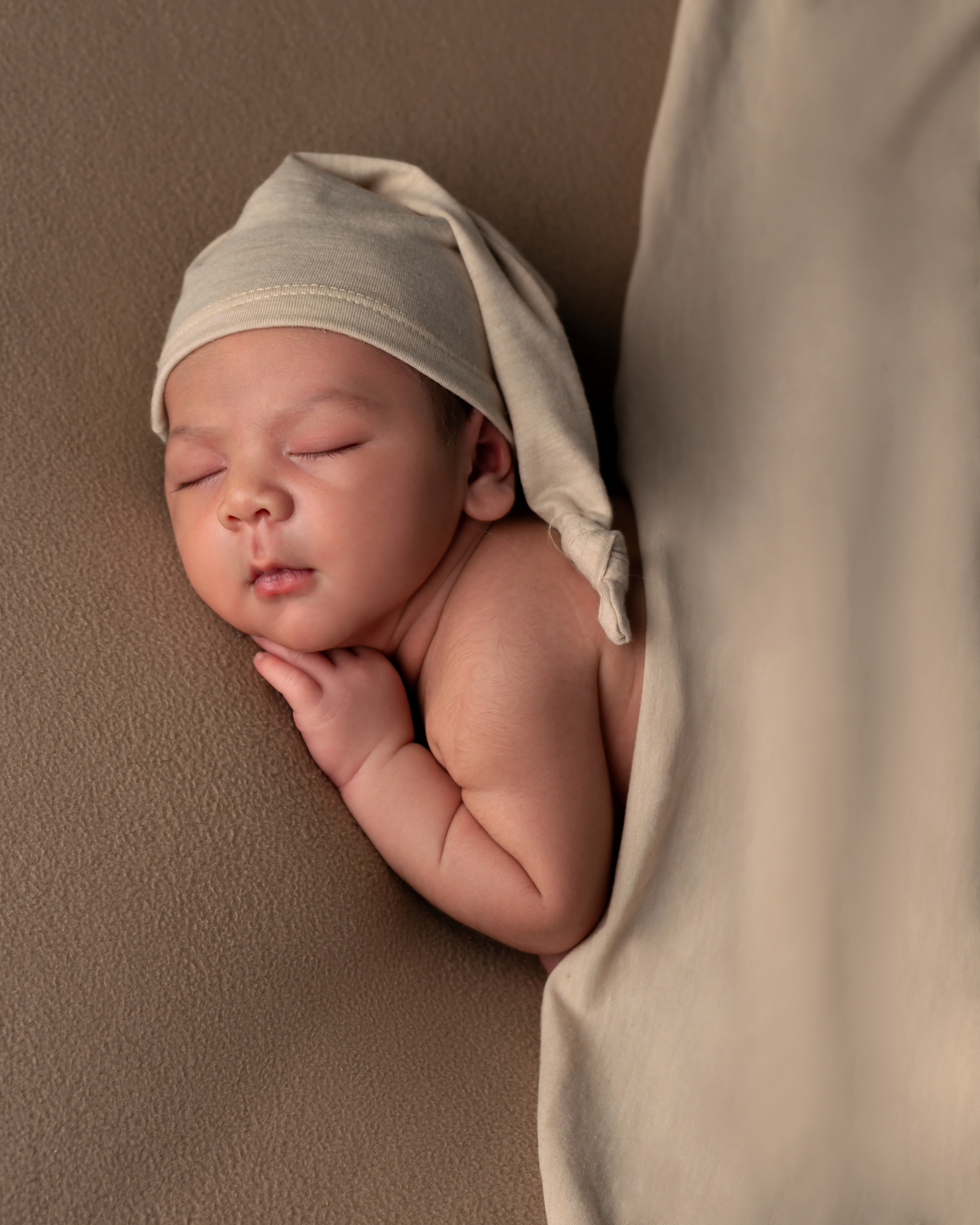 Bebê dormindo no poof com gorrinho. Ensaio Newborn com Amoradia Foto. Natal/RN