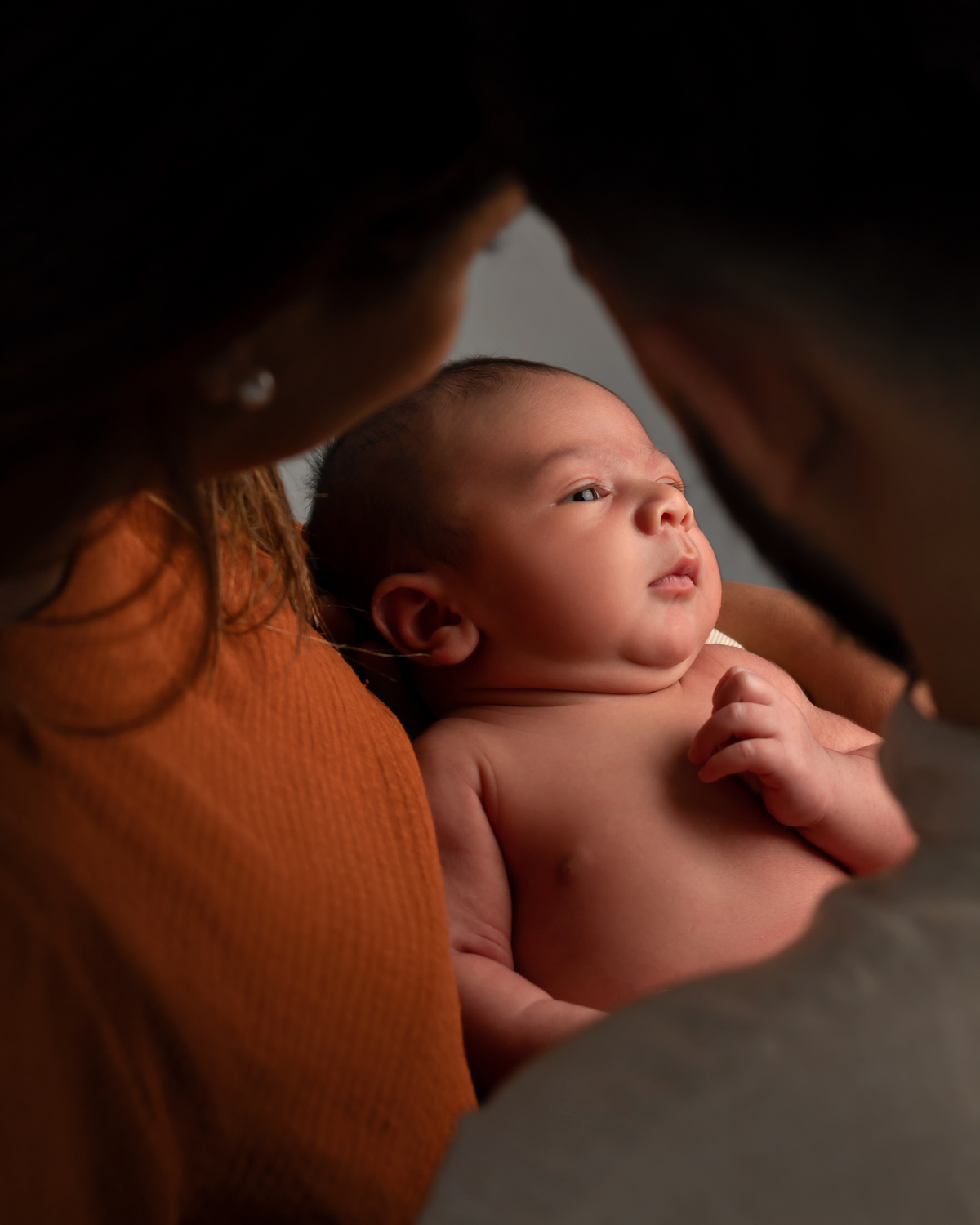 Bebê no colo dos pais. Ensaio Newborn RN. Amoradia Foto. Estúdio do Bebê.