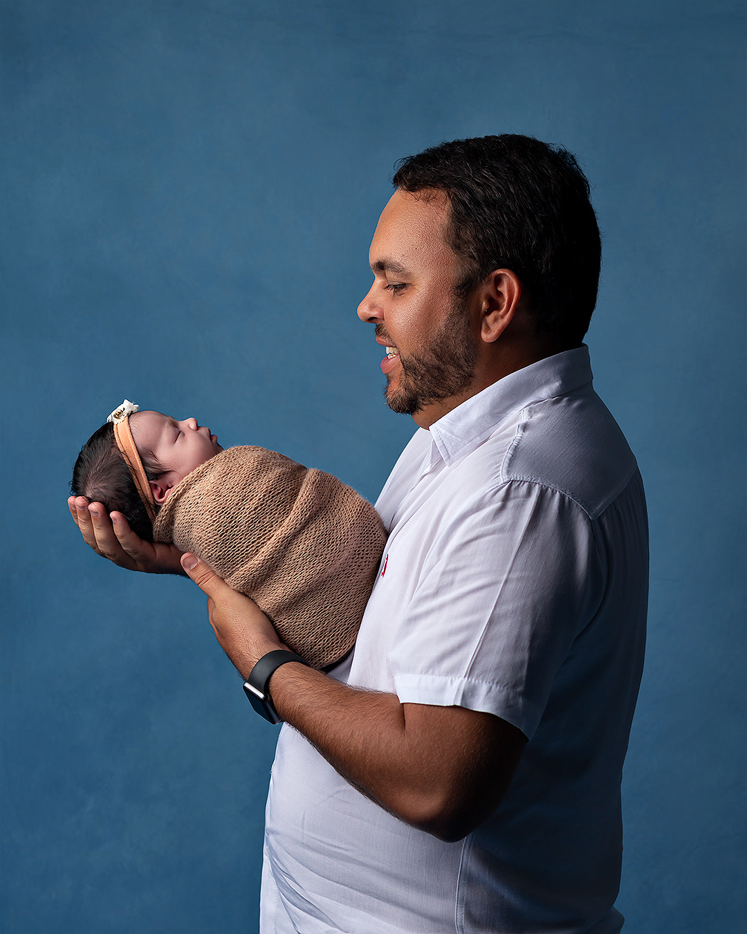 Pai segurando filha em ensaio newborn em Natal.