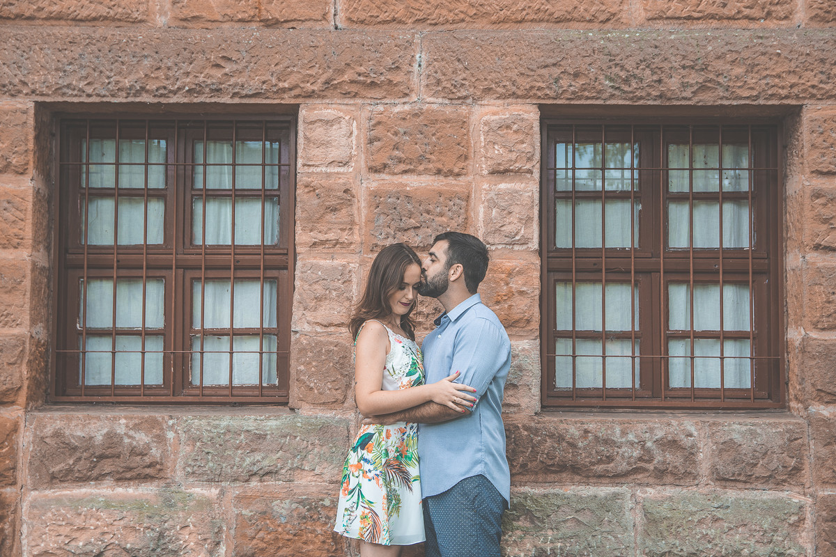 noivo beijando testa da noiva entre duas janelas