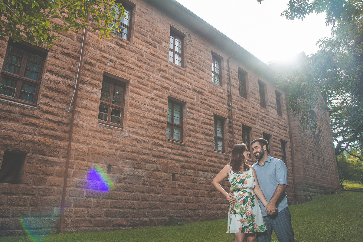 casal com sol e prédio ao fundo