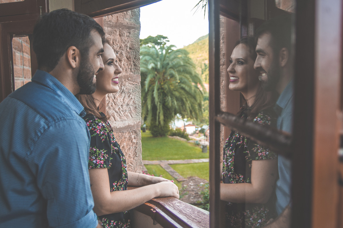 casal na janela com reflexo deles aparecendo