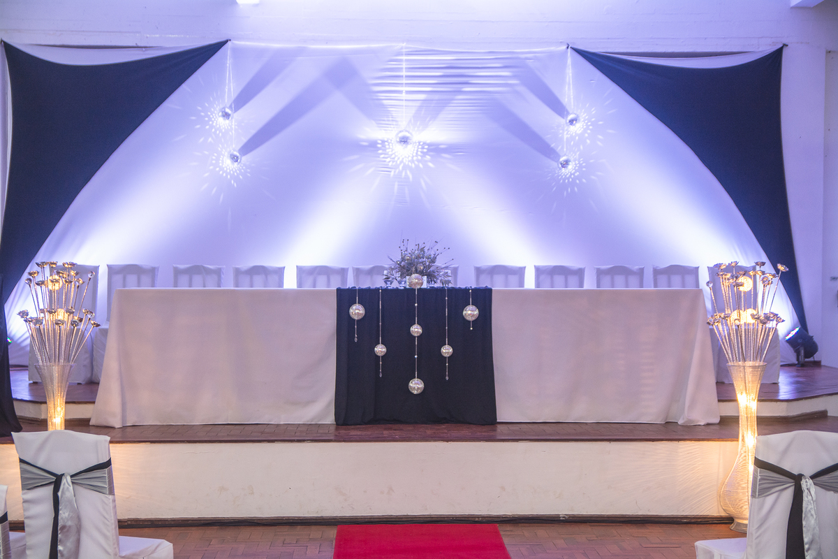 Visão geral da mesa dos professores com globos de luz no teto