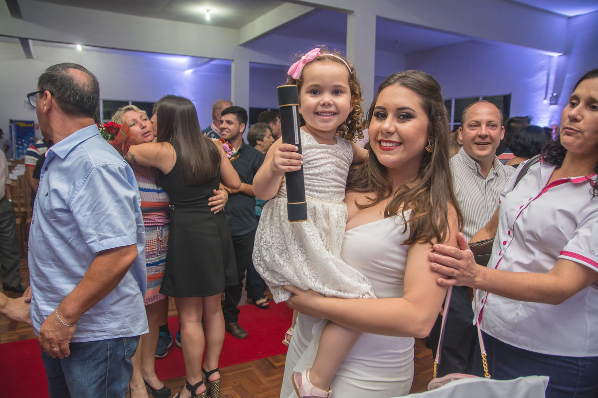 Formanda com criança no colo feliz