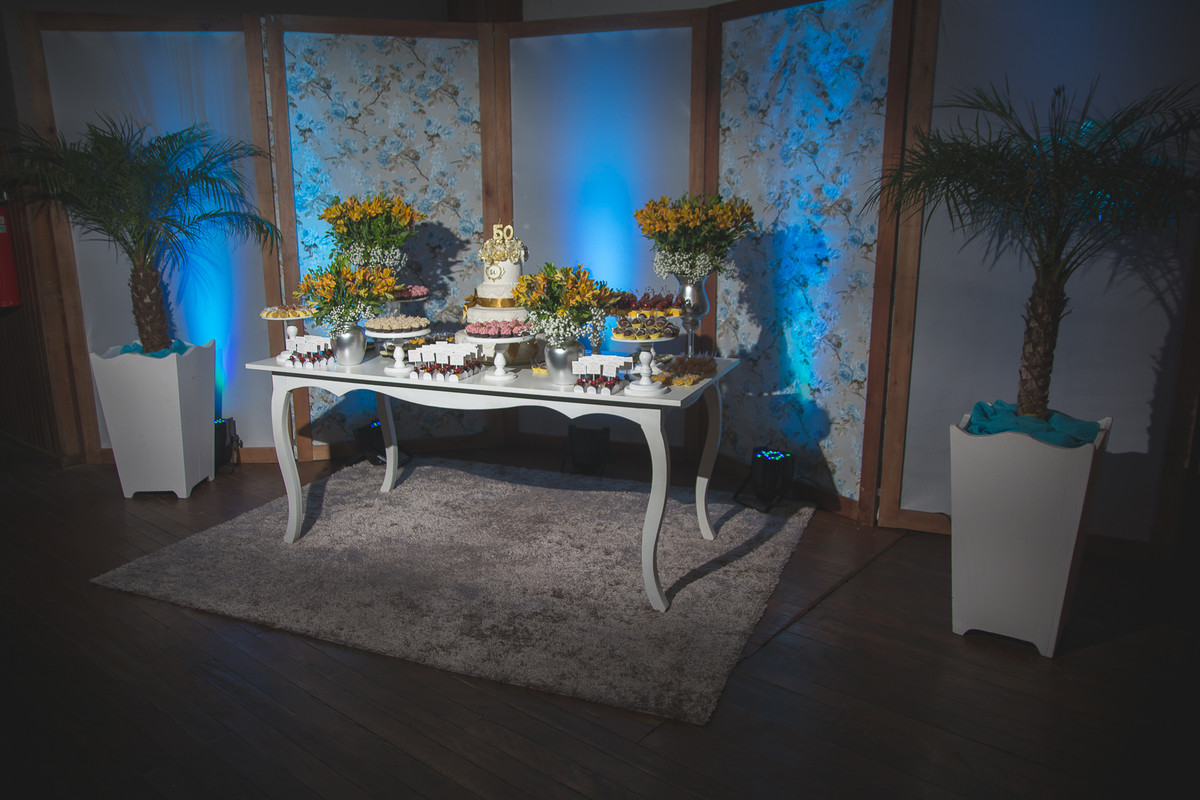 Mesa decorada com doces e bolo