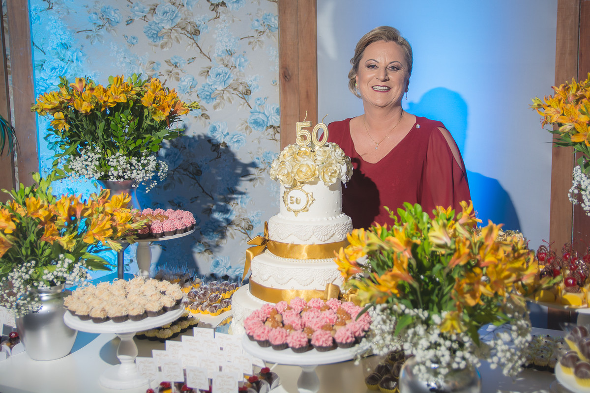 Aniversariante atrás da mesa com bolo