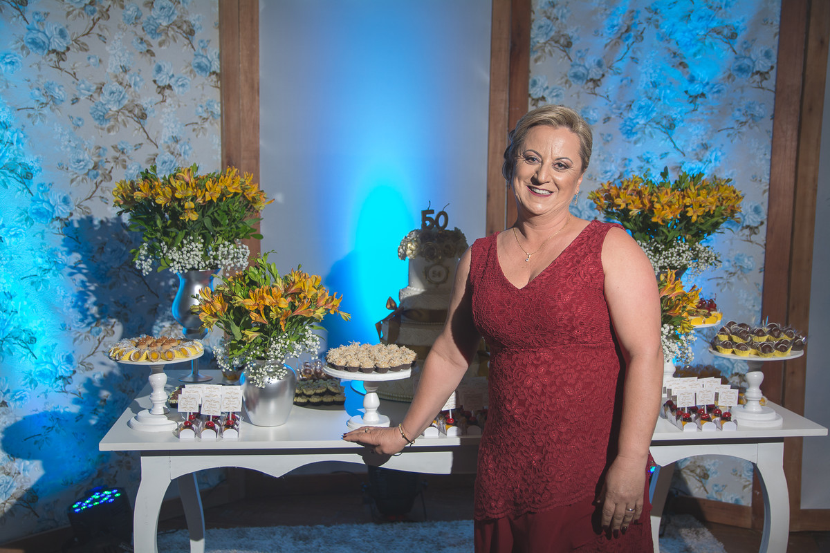 Aniversariante posando em frente a mesa decorada