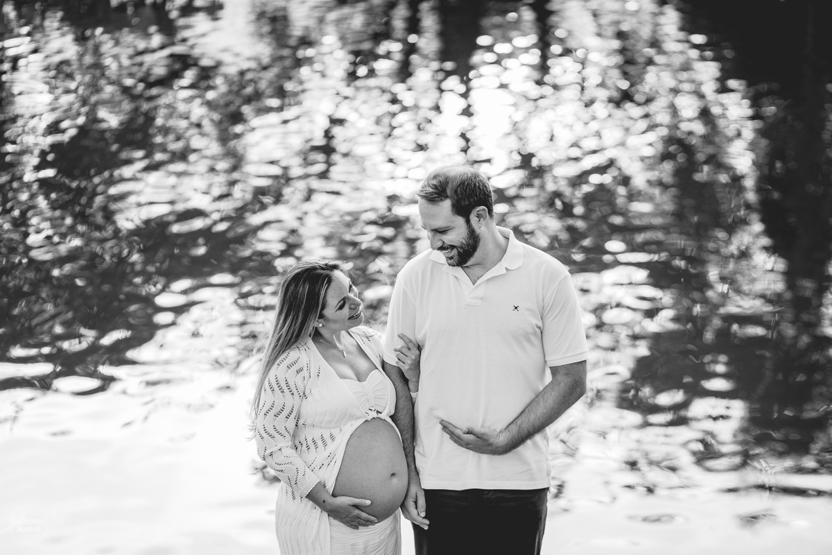 Book de Gestante por Guilherme Santos Fotografia que rolou no Hotel Fazenda Shangri-la, Brotas-SP. Sessão fotográfica no final de tarde, casal gravidos se abraçando na beira de um lado.