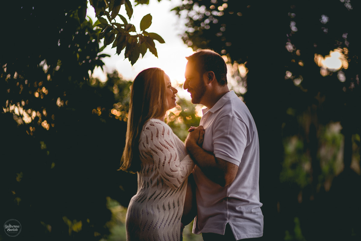 Book de Gestante por Guilherme Santos Fotografia que rolou no Hotel Fazenda Shangri-la, Brotas-SP. Sessão fotográfica no final de tarde, casal gravidos se olhando e sorrindo junto ao por do sol.