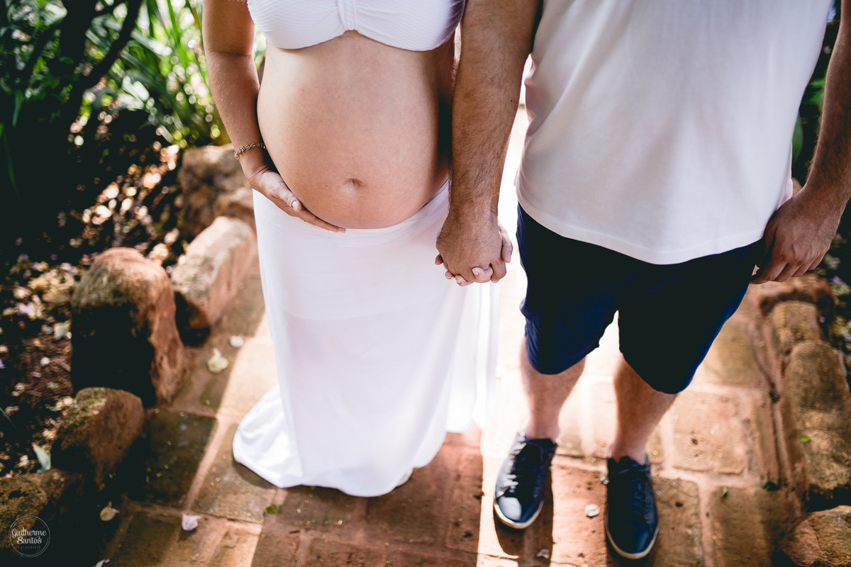 Book de Gestante por Guilherme Santos Fotografia que rolou no Hotel Fazenda Shangri-la, Brotas-SP. Sessão fotográfica no final de tarde, casal de mãos dadas mostrando a barriga de gravida.