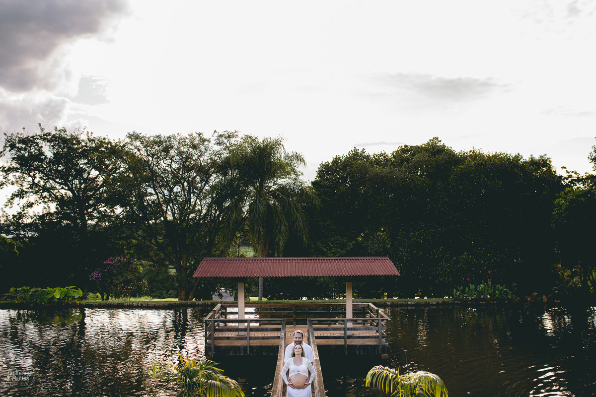 Book de Gestante por Guilherme Santos Fotografia que rolou no Hotel Fazenda Shangri-la, Brotas-SP. Sessão fotográfica no final de tarde, casal se abraçando em um deck, barrigão de gravida.