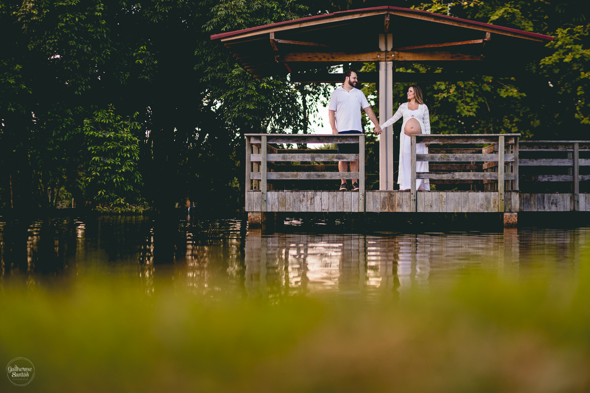 Book de Gestante por Guilherme Santos Fotografia que rolou no Hotel Fazenda Shangri-la, Brotas-SP. Sessão fotográfica no final de tarde, casal se abraçando em um deck, barrigão de gravida.