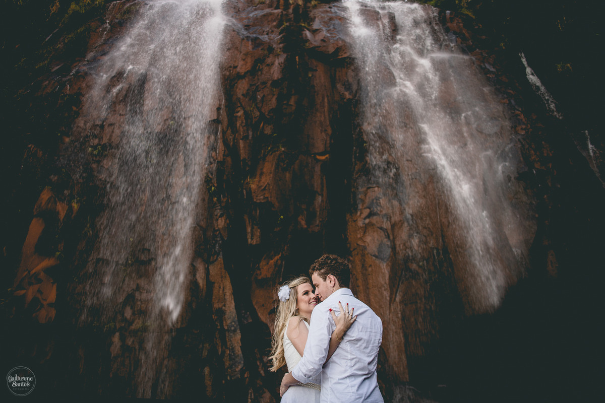 Fotografia de pré casamento feita no final de tarde pelo fotógrafo Guilherme Santos, casal de noivos se abraçando na sessão de fotos, sessão pré wedding na cachoeira em Brotas.