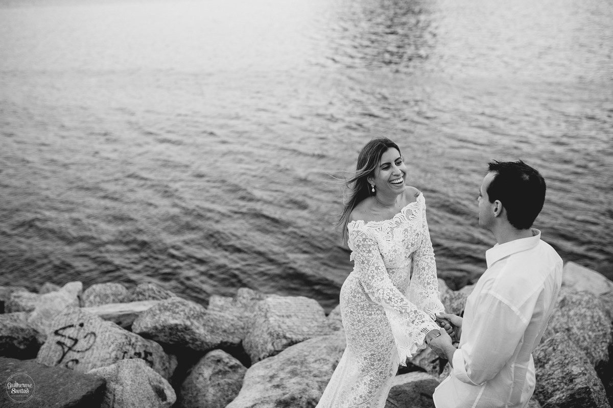 Fotografia de pré casamento pelo fotógrafo Guilherme Santos, casal felizes se olhando diante do mar na sessão de fotos no Rio de Janeiro.