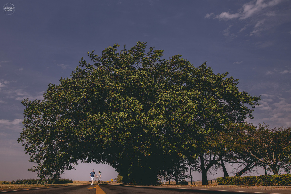 Fotografia de pré casamento feita pelo fotógrafo Guilherme Santos, casal de noivos caminhando na rodovia em São Carlos.