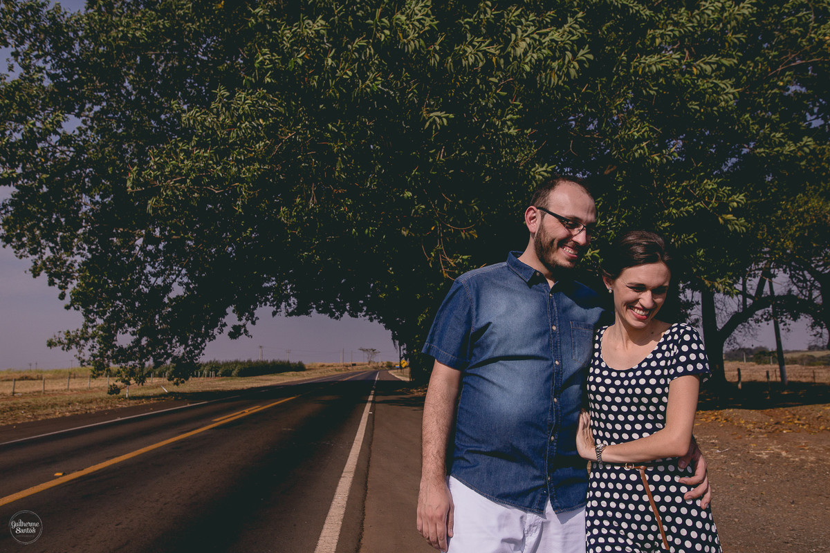 Fotografia de pré casamento feita pelo fotógrafo Guilherme Santos,  casal de noivos se abraçando sorrindo perto de São Carlos, sessão de fotos na rodovia.