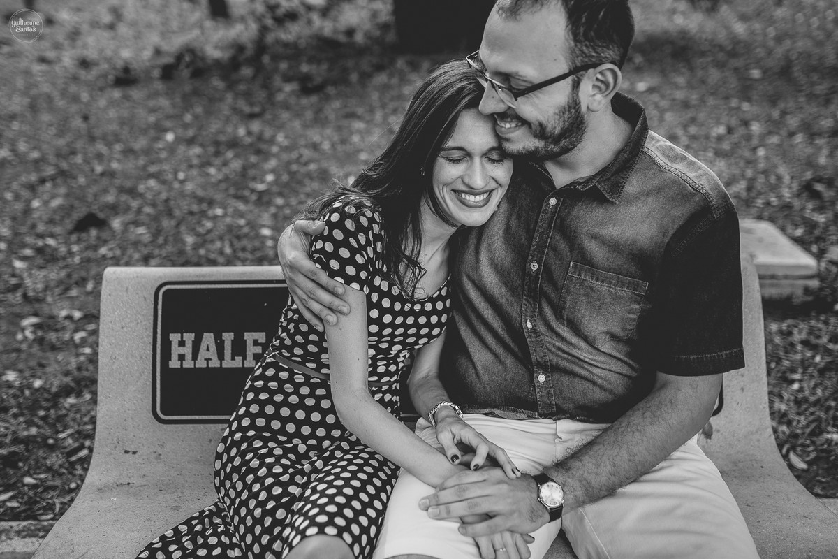 Fotografia de pré casamento feita pelo fotógrafo Guilherme Santos, casal de noivos sentados em um banco da praça na sessão de fotos em São Carlos.