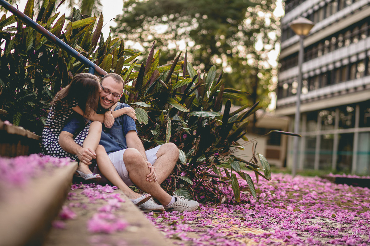 Fotografia de pré casamento feita pelo fotógrafo Guilherme Santos, casal de noivos sentados perto das flores, 
