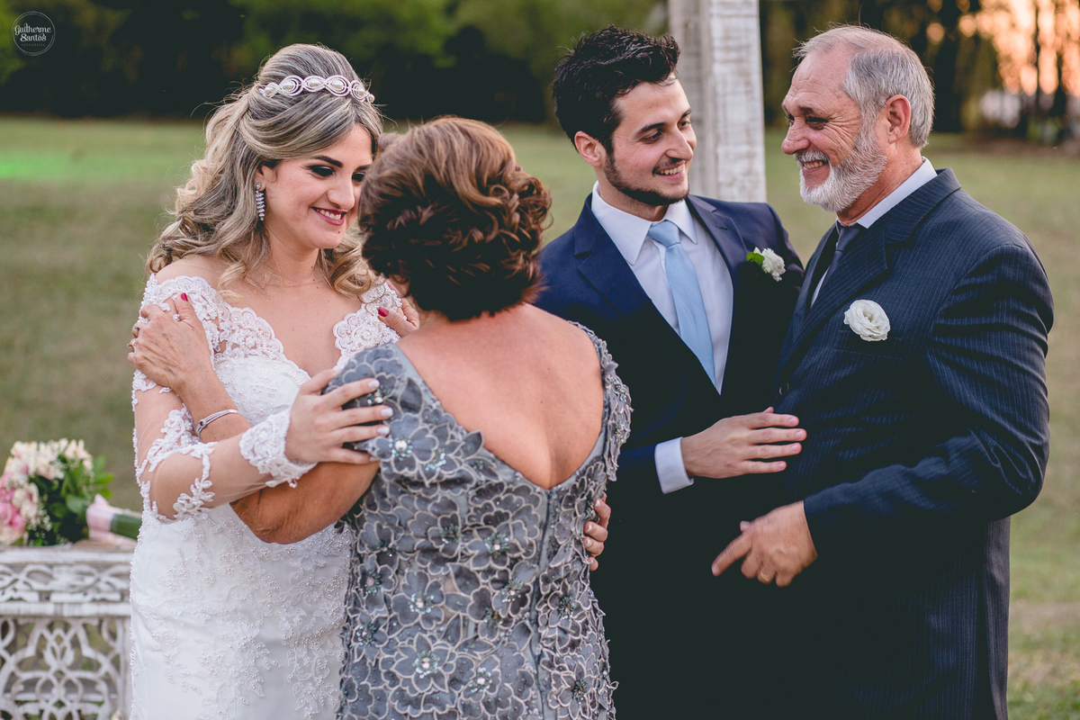 Fotografia de casamento pelo fotógrafo Guilherme Santos, casal de noivos abraçando os padrinhos ao fim da cerimônia de casamento ao ar livre em Pederneiras.