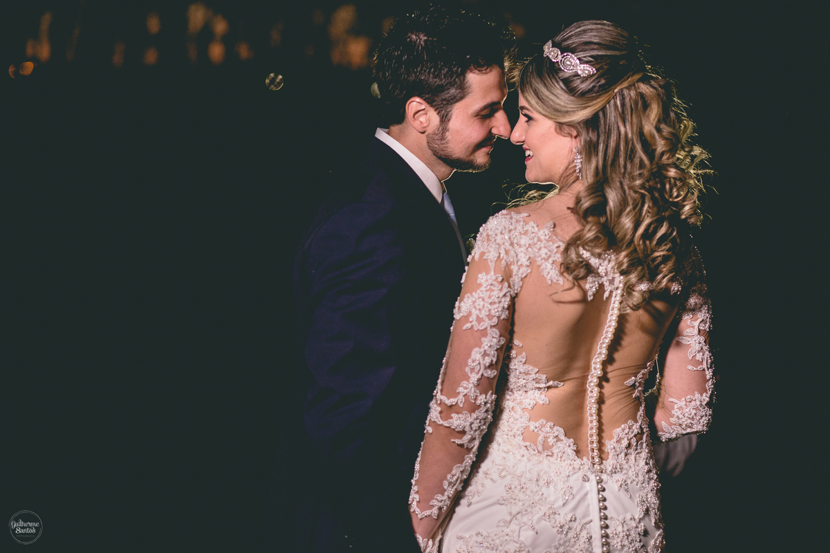 Fotografia de casamento pelo fotógrafo Guilherme Santos, casal de noivos se olhando e sorrindo na sessão de fotos. Detalhes no vestido de noiva.