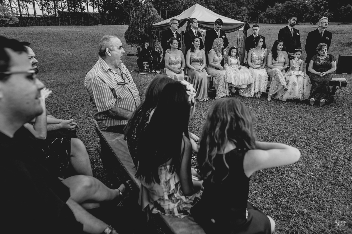 Fotografia de casamento pelo fotógrafo Guilherme Santos, convidados olhando os noivos na cerimônia de casamento ao ar livre.