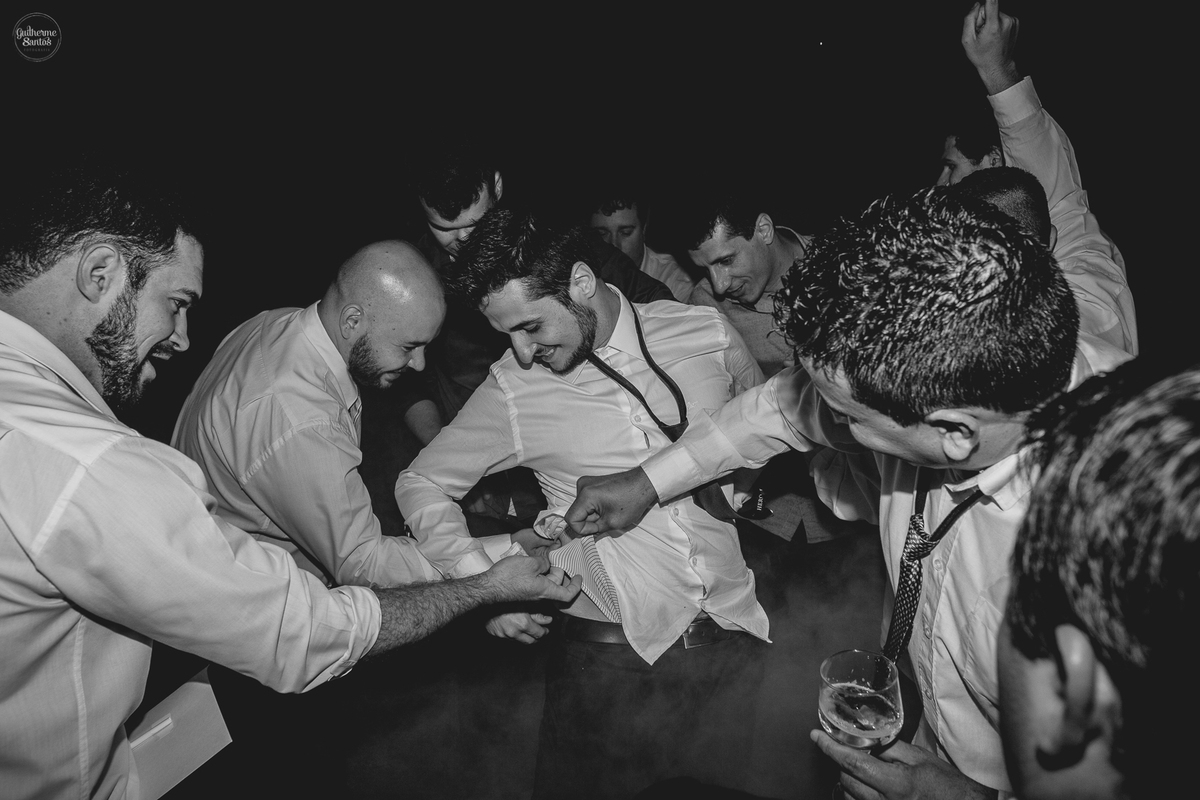 Fotografia de casamento pelo fotógrafo Guilherme Santos, noivo com os padrinhos no momento da gravata.