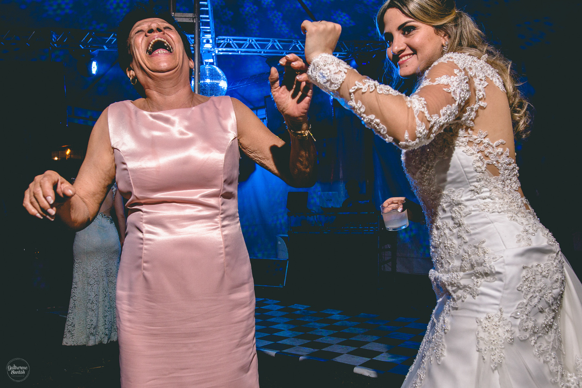 Fotografia de casamento pelo fotógrafo Guilherme Santos, noiva dançando com os convidados na festa de casamento ao ar livre.