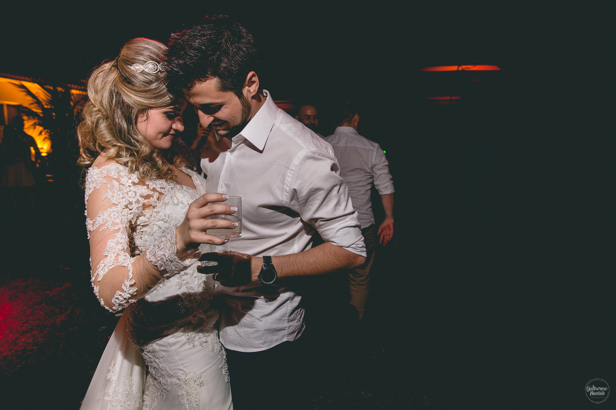 Fotografia de casamento pelo fotógrafo Guilherme Santos, casal de noivos dançando juntos na festa de casamento ao ar livre.