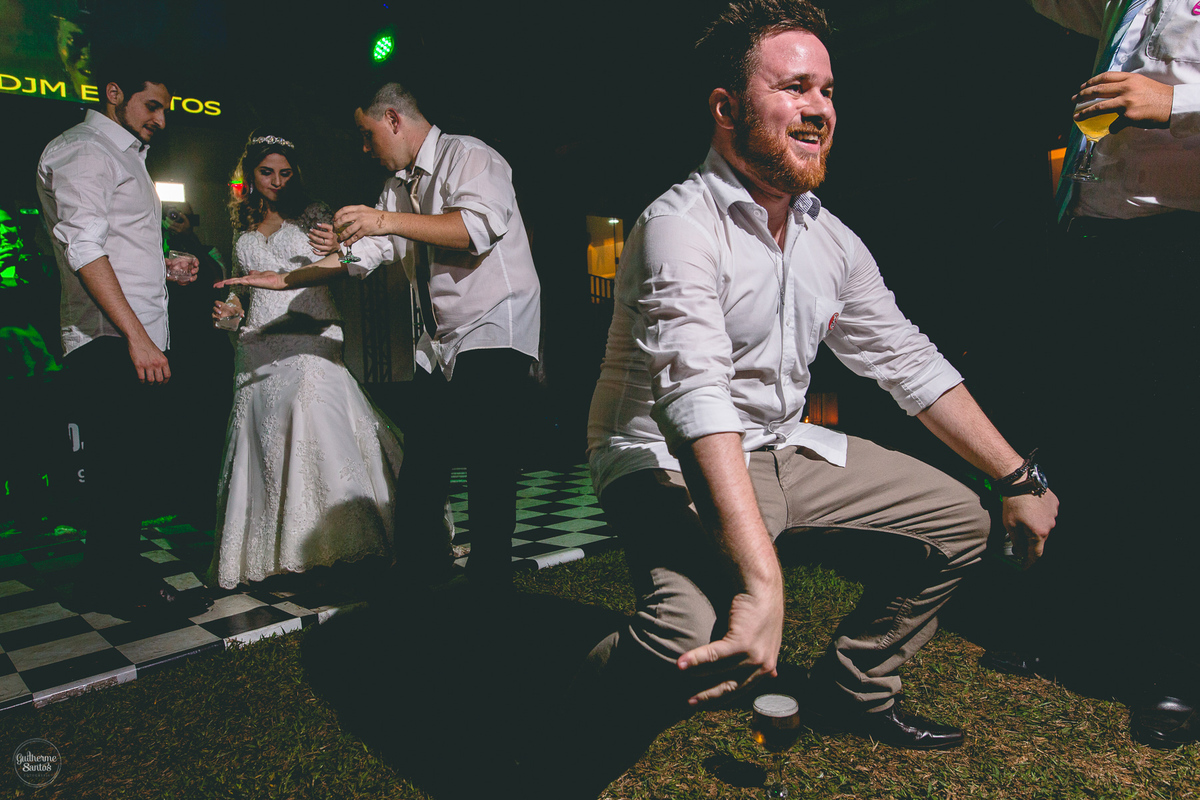 Fotografia de casamento pelo fotógrafo Guilherme Santos, convidados animados dançando na festa de casamento.