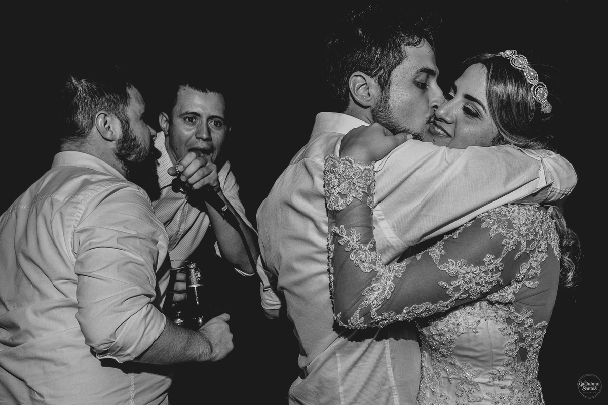 Fotografia de casamento pelo fotógrafo Guilherme Santos, noivo abraçando e beijando a noiva na festa de casamento em Pederneiras,