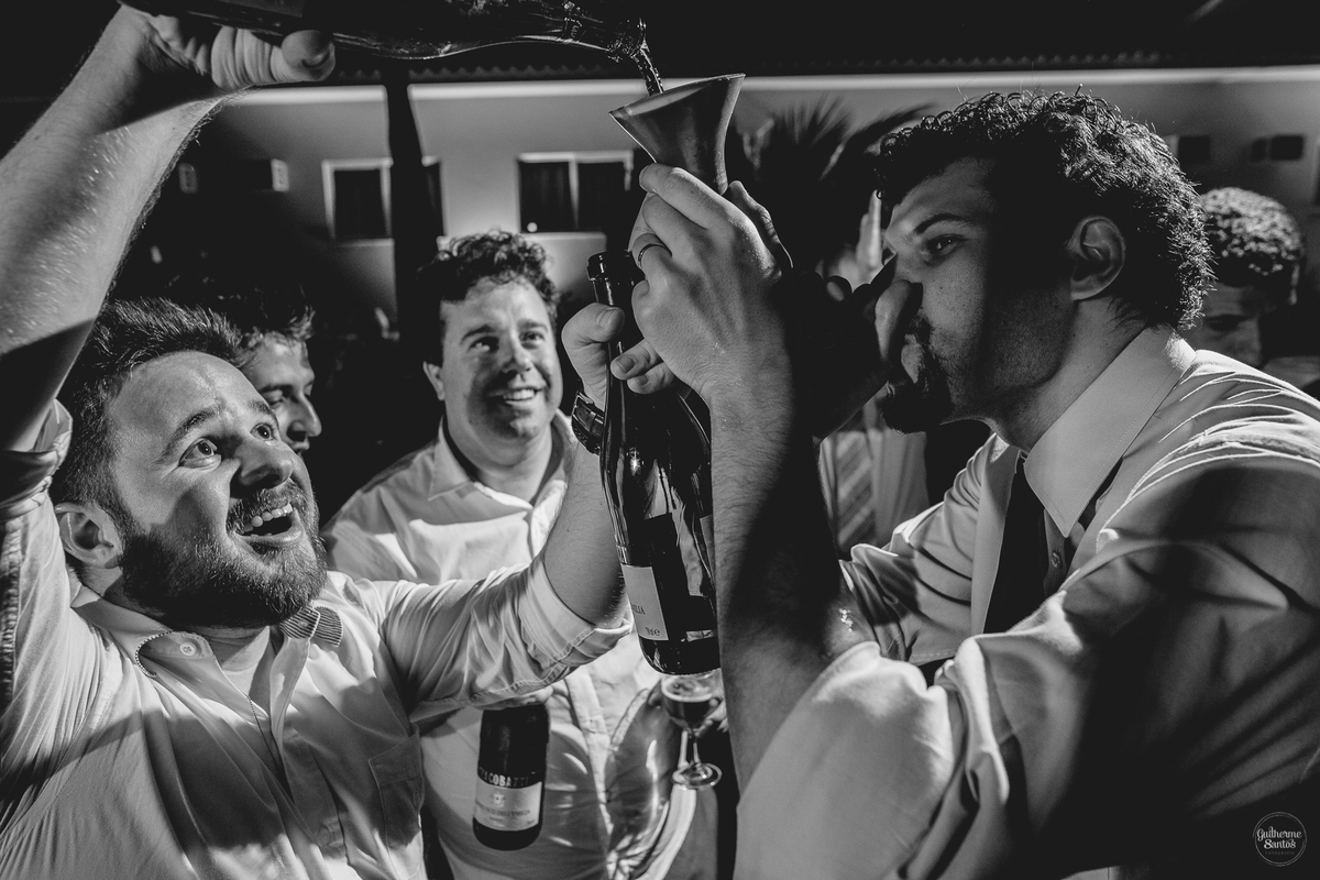 Fotografia de casamento pelo fotógrafo Guilherme Santos, convidados animados bebendo durante a festa de casamento.