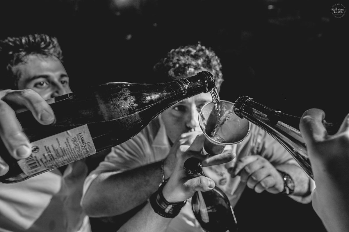 Fotografia de casamento pelo fotógrafo Guilherme Santos, convidados felizes bebendo durante a festa de casamento ao ar livre.
