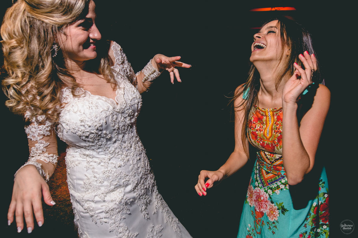 Fotografia de casamento pelo fotógrafo Guilherme Santos, noiva feliz dançando com a madrinha durante a festa de casamento ao ar livre em Pederneiras.