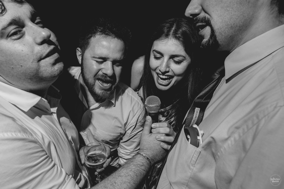 Fotografia de casamento pelo fotógrafo Guilherme Santos, convidados cantando na festa de casamento ao ar livre.