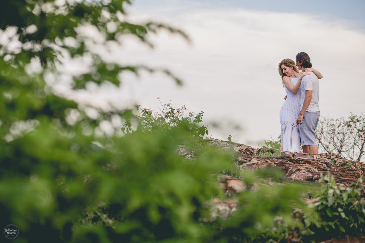 Fotografia de pré casamento pelo fotógrafo Guilherme Santos, noivo vendo a paisagem na sessão de fotos. Casal de noivos se abraçando na sessão pré casamento em Botucatu.