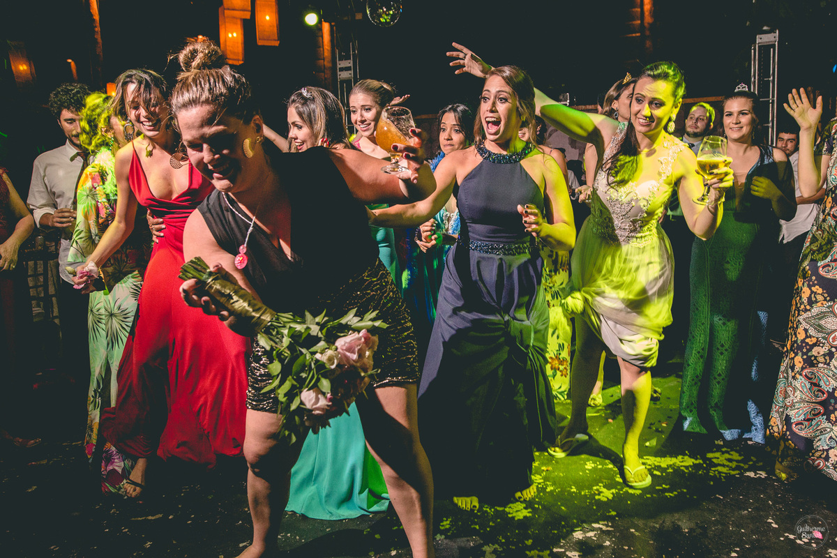 Fotografia de casamento pelo fotógrafo Guilherme Santos, convidada pegou o buquê na festa de casamento em Botucatu.