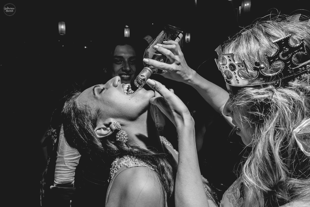 Fotografia de casamento pelo fotógrafo Guilherme Santos, noiva oferecendo whisky durante a festa de casamento em Botucatu.