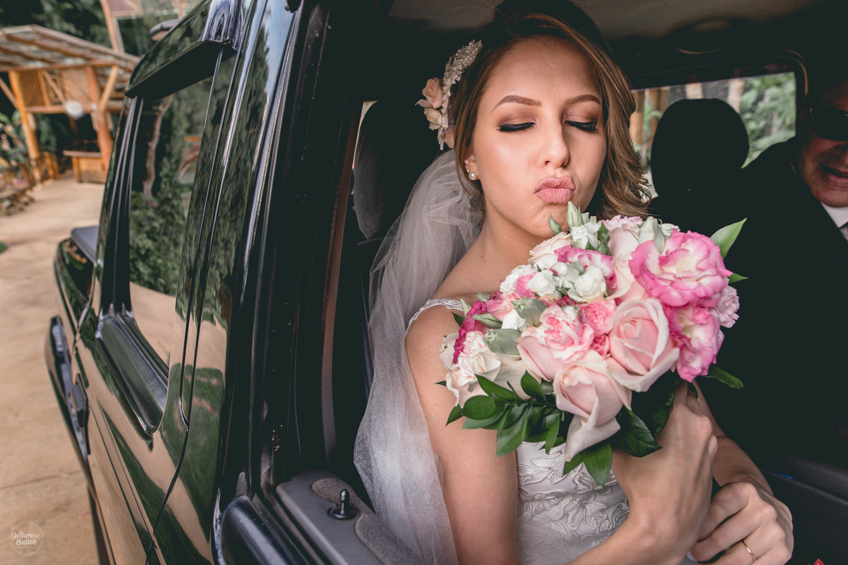 Fotografia de casamento feita no final de tarde pelo fotógrafo Guilherme Santos, noiva segundo o buquê momentos antes do início de seu casamento ao ar livre em Brotas.