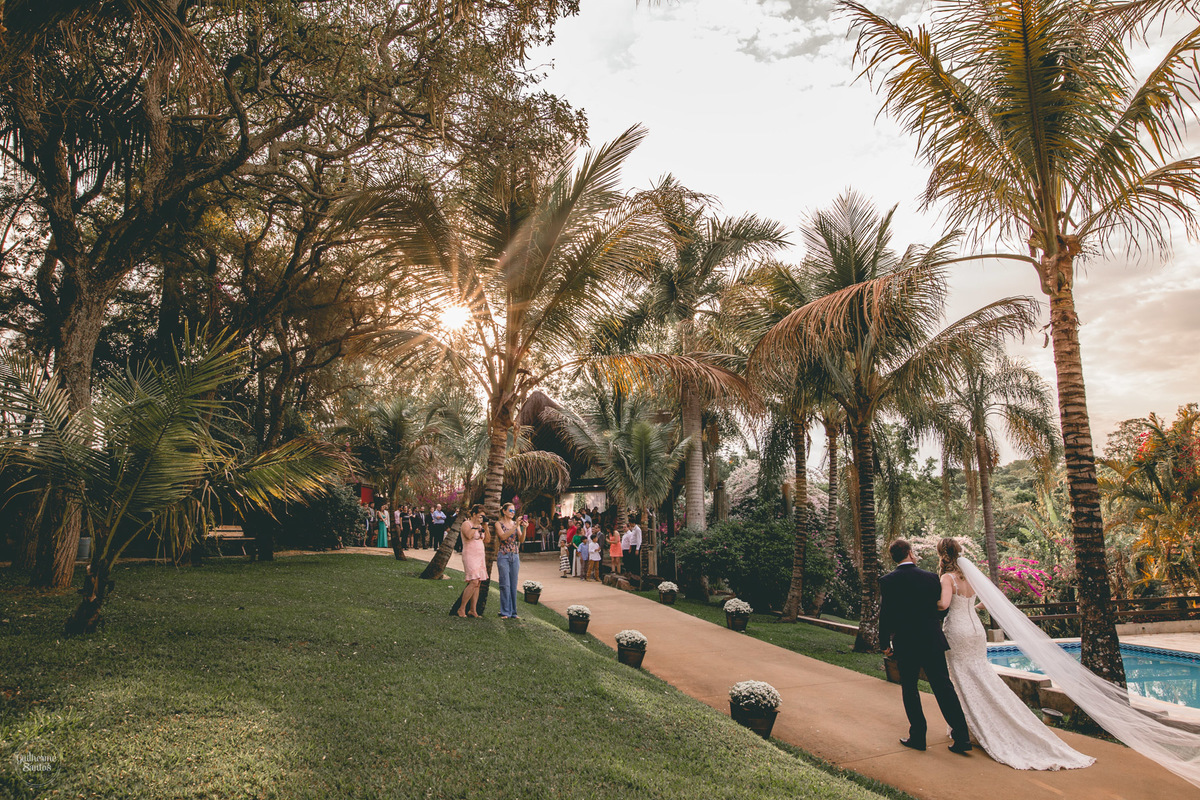Fotografia de casamento feita no final de tarde pelo fotógrafo Guilherme Santos, noiva entrando no casamento com seu pai. Casamento ao ar livre com pôr do sol. Casamento em Botucatu.