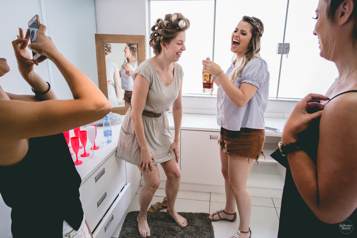 Fotografia de casamento pelo fotógrafo Guilherme Santos, noiva e madrinhas se divertindo juntas durante os preparativos do casamento.