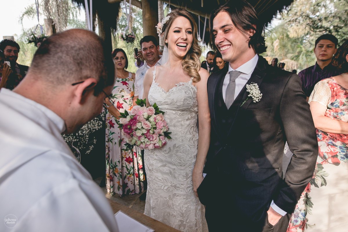 Fotografia de casamento feita no final de tarde pelo fotógrafo Guilherme Santos, casal de noivos estão no altar, casal sorrindo no casamento ao ar livre em Botucatu.