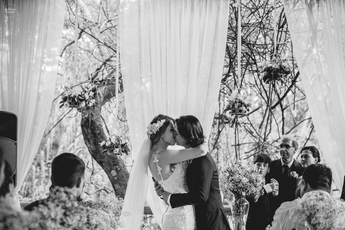 Fotografia de casamento feita no final de tarde pelo fotógrafo Guilherme Santos, casal de noivos se beijando durante a cerimônia no casamento ao ar livre em Botucatu.