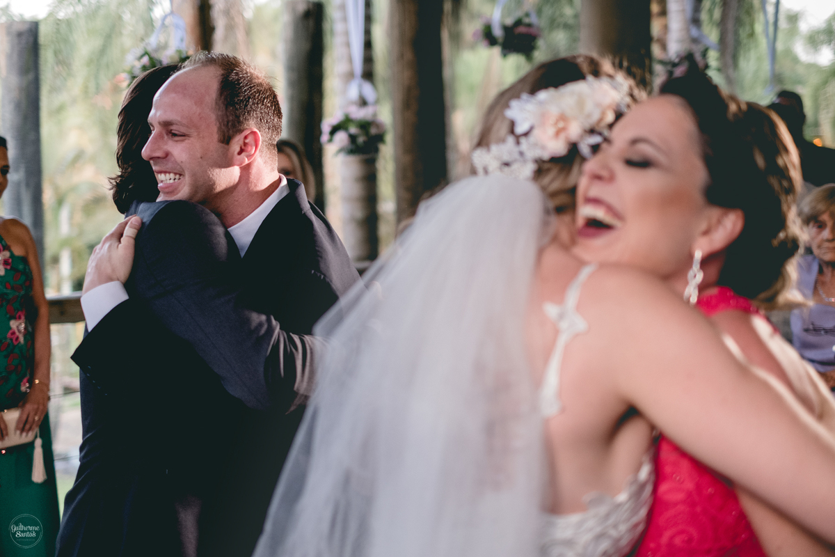 Fotografia de casamento feita no final de tarde pelo fotógrafo Guilherme Santos, noivos abraçando os padrinhos no casamento ao ar livre em Botucatu.